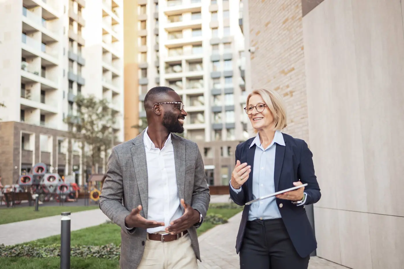 Smiling Colleagues Discussing Business In Urban Environment